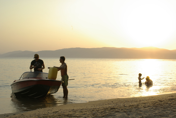 Boat Boys refueling their speed boat on the beach at sunset, Skiathos, Greece. The correct exposure. 